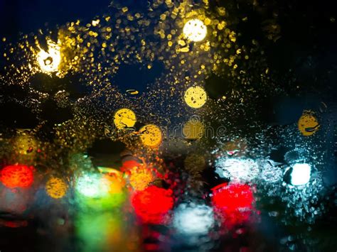 Blurred Rain Drops On Car Window With Road Light Bokeh On Rainy Season