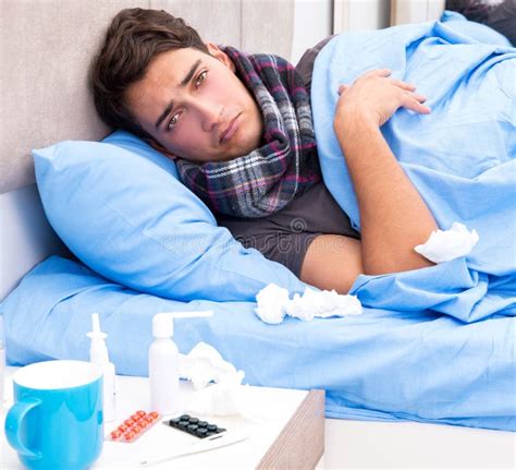 Sick Man Lying In Bed Suffering Cold And Winter Flu Virus Having