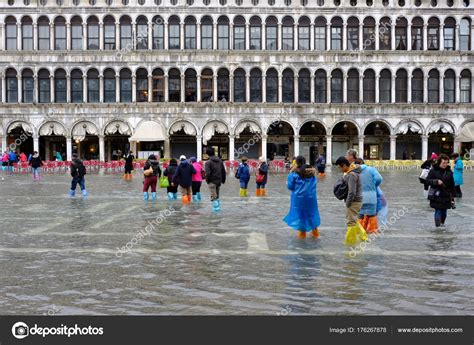 Tourists Walking Along Flooding Piazza San Marco In Venice Stock
