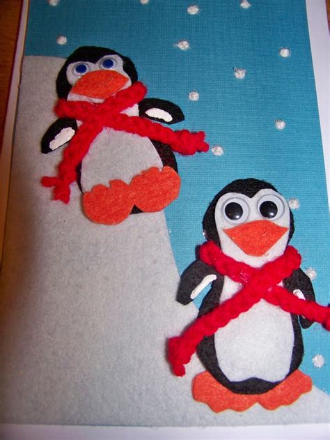Two Felt Penguins Are Standing Next To Each Other On A Blue And White