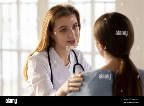 Supportive Female Doctor Comfort Patient At Consultation Stock Photo
