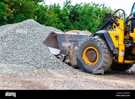 Yellow Wheel Loader Bulldozer Is Working In Quarry Against The