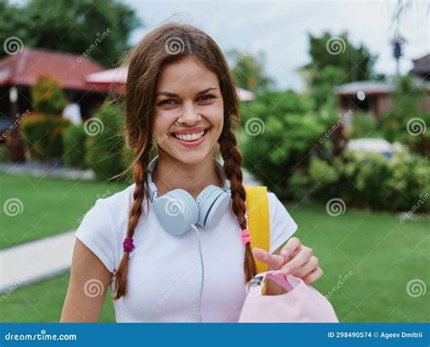 A Teenage High School Girl In A Pink Cap With A Backpack And Headphones