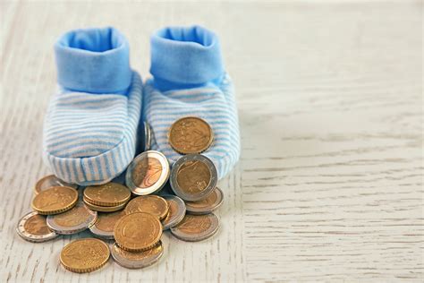 Parenting Expenses Concept Baby Booties And Pile Of Coins Hopping In