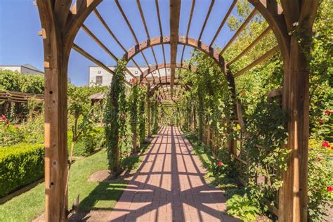 Beautiful Garden Wedding Venue With A Wooden Arbor Wrapped With Vibrant