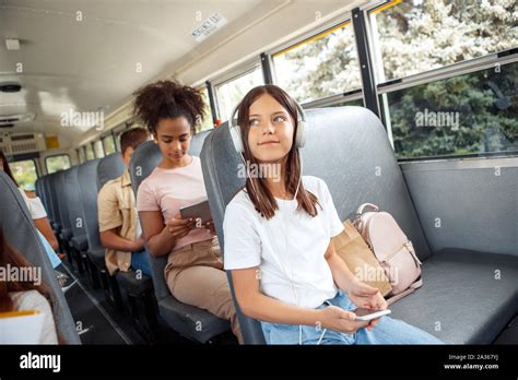 Classmates Going To School By Bus Sitting Girl Close Up In Headphones Listening Music Holding