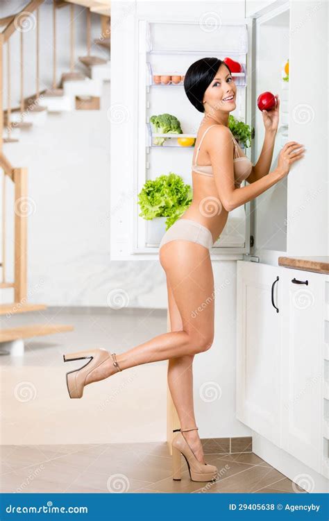 Full Length Portrait Of Woman Near The Opened Refrigerator Stock Photo
