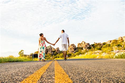 Couple Holding Hands On Mountain Road · Free Stock Photo