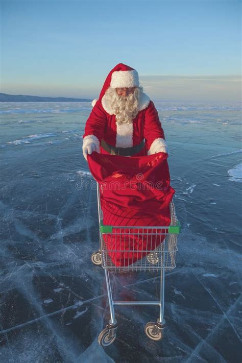 Santa Claus Carries A Shopping Cart With Ts In A Sack Stock Photo
