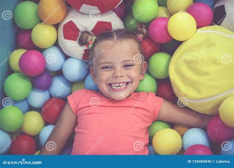 Caucasian Girl Lying On Colored Ball Little Girl Playing In Playground