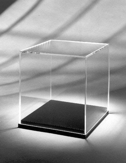 A Black And White Photo Of A Square Glass Box On A Table With Shadows In The Background