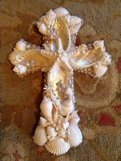 A Cross Made Out Of Seashells On The Ground