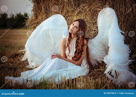 Beautiful Girl With Angel Wings Is Sitting Front Of The Hay Stock Image
