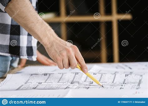 Young Adult Architect Working With Blueprints In Workplace Studio Stock