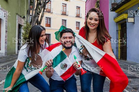 Grupo De Mexicanos Felices Sosteniendo Banderas En La Fiesta Mexicana