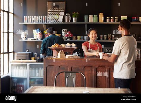 Staff Serving Customer In Busy Coffee Shop Stock Photo Alamy