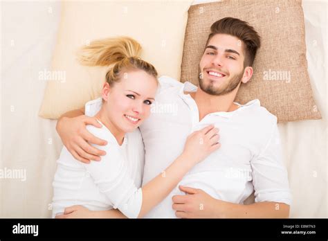 A Happy Young Couple Hugging In Bed Stock Photo Alamy
