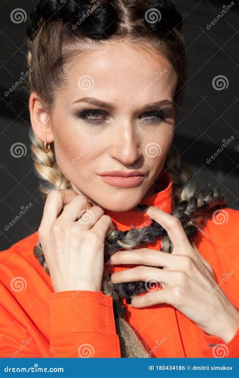 Portrait Of A Beautiful Woman With Braids In Orange Clothes Stock Photo