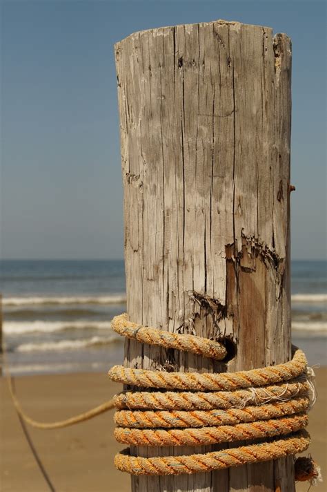 A Rope Tied To A Wooden Post On The Beach