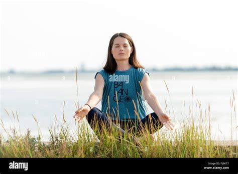 Woman Sitting Crossed Legged And Meditating Stock Photo Alamy