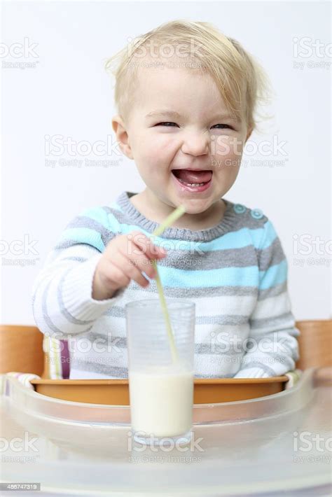 Toddler Girl Drinking Milk In Glass From Straw Stock Photo Download