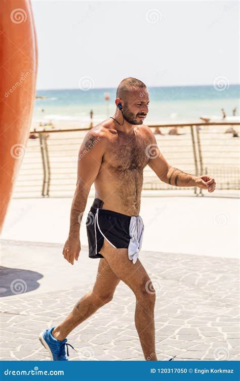 Handsome Israeli Man Walking Along The Beach Promanade Of Tel Av