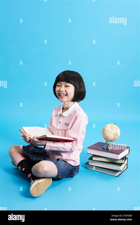 Young Girl Reading Book Smiling Studio Shot Stock Photo Alamy