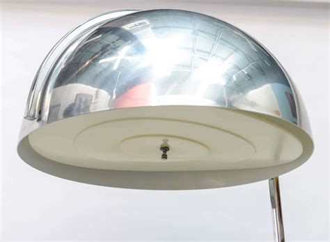 An elegant combination of soft and rigid lines, this exquisitely handcrafted floor lamp juxtaposes the metal of the structure with the glass of the light. Chrome Dome Floor Lamp with End Table at 1stdibs