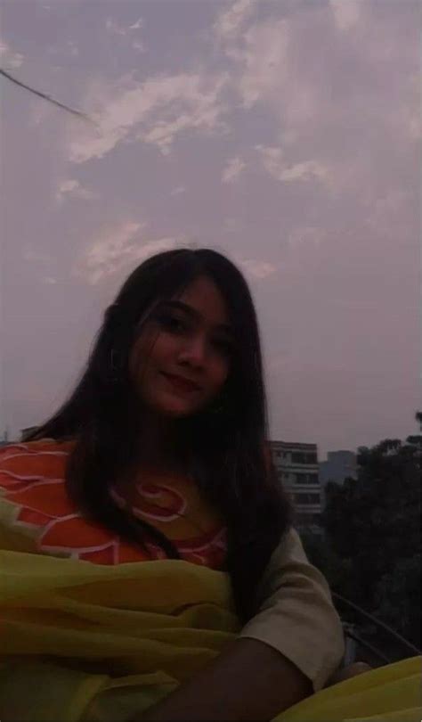 A Woman Is Smiling While Standing Under A Kite In The Sky With