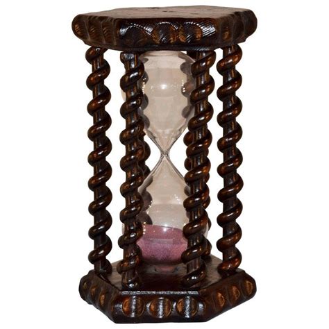 An Hourglass Is Sitting On Top Of A Wooden Stand