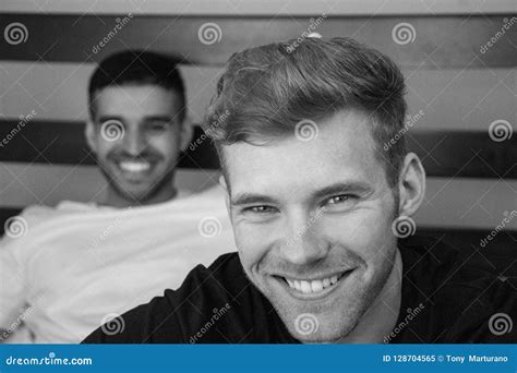Gay Lovers Sitting In Bed With One Close To Camera And The Other