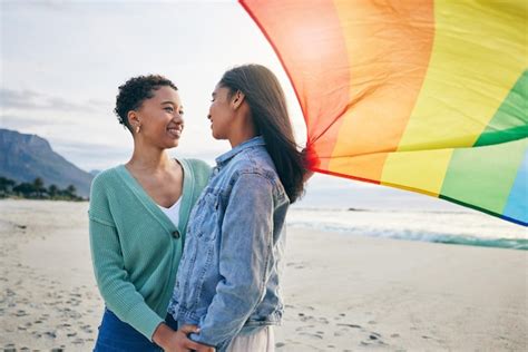 premium photo gay flag and lesbian couple at the beach for travel