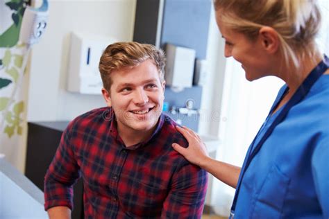 Male Patient Being Reassured By Nurse In Hospital Room Stock Image