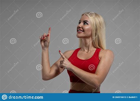 blonde woman in a red top points her fingers up to the left stock image image of boobs