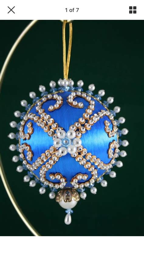 A Blue Ornament Hanging From A Gold Hoop With Pearls And Beads On It
