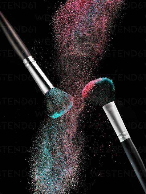 Coloured Make Up Powder And Two Beauty Brushes In Front Of Black