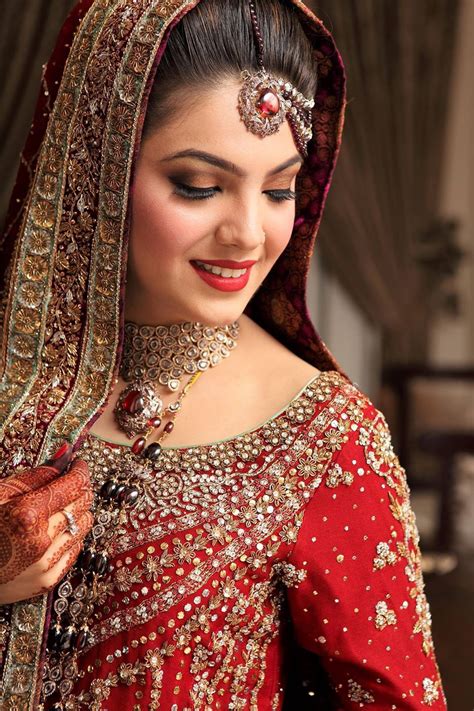 a woman wearing a red bridal outfit and jewelry