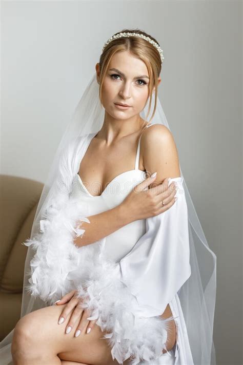 Gorgeous Beautiful Bride In Silk Robe Posing Near Window In Soft Light
