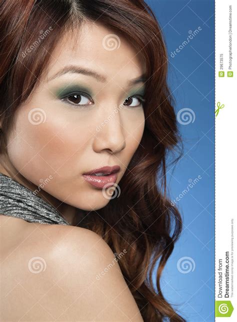 Portrait Of Beautiful Young Woman Looking Back Over Colored Background