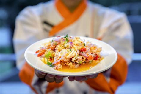 Traditional Thai Spicy Noodle Vermicelli With Seafood Shrimp Squid And Thai Herb On Cook Hand