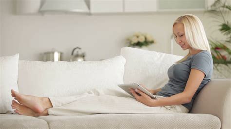 Pretty Girl Sitting On Couch Using Touchpad Stock Footage SBV