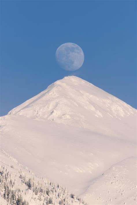 Full Moon Rising Behind A Snowy Mountain Stock Photo Image Of North