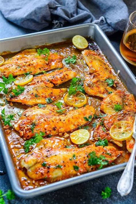 Baked Tilapia O A Baking Tray Along With A Glass Of Wine Fish Recipes