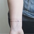 Delicato tatuaggio bracciale donna con punti e freccia