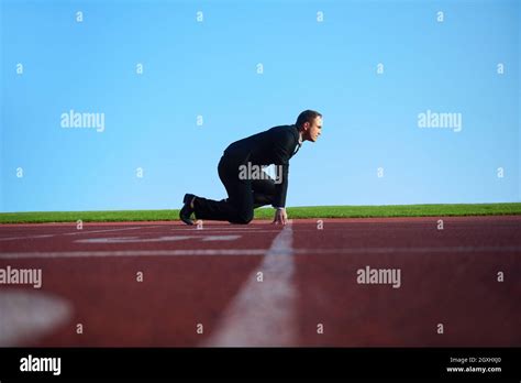 Business Man In Start Position Ready To Run And Sprint On Athletics