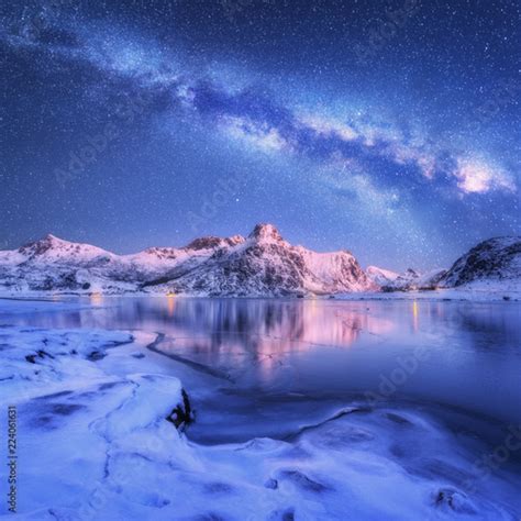 Milky Way Above Frozen Sea Coast And Snow Covered Mountains In Winter