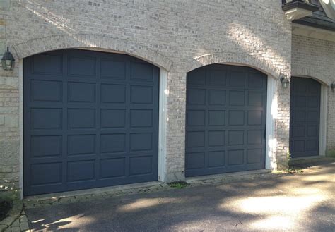 The arched door openings are decorated with stone clad details that make a nice focal point and give a boost to the curb appeal of this beautiful house. Chicago Garage Door Refinishing | Ragsdale, Inc