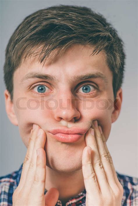 Young Man Squeezing Her Cheeks With Her Hands Stock Image Colourbox