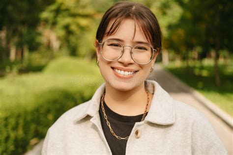 Portrait Of Young Trendy Woman Wearing Eyeglasses Smiling And Looking