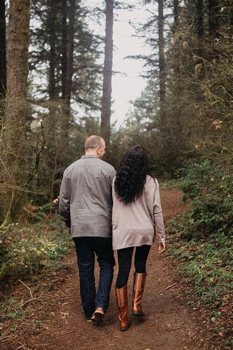 Couple Walking Together On Path In Woods Del Colaborador De Stocksy